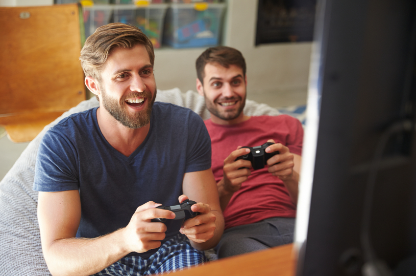 two-male-friends-in-pajamas-playing-video-game-together